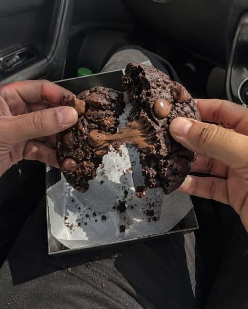 AI render in a candid style: two hands pulling apart a gooey cookie