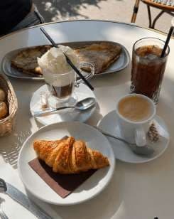 AI render: croissant with coffee and an iced drink on a café table