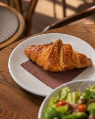 AI render: croissant on a plate beside a salad