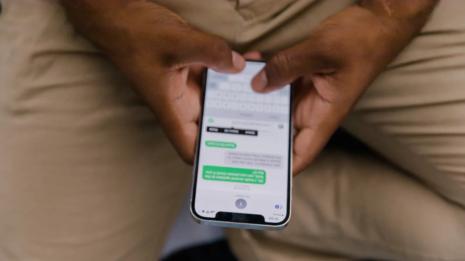 Close-up of hands typing a message on a phone
